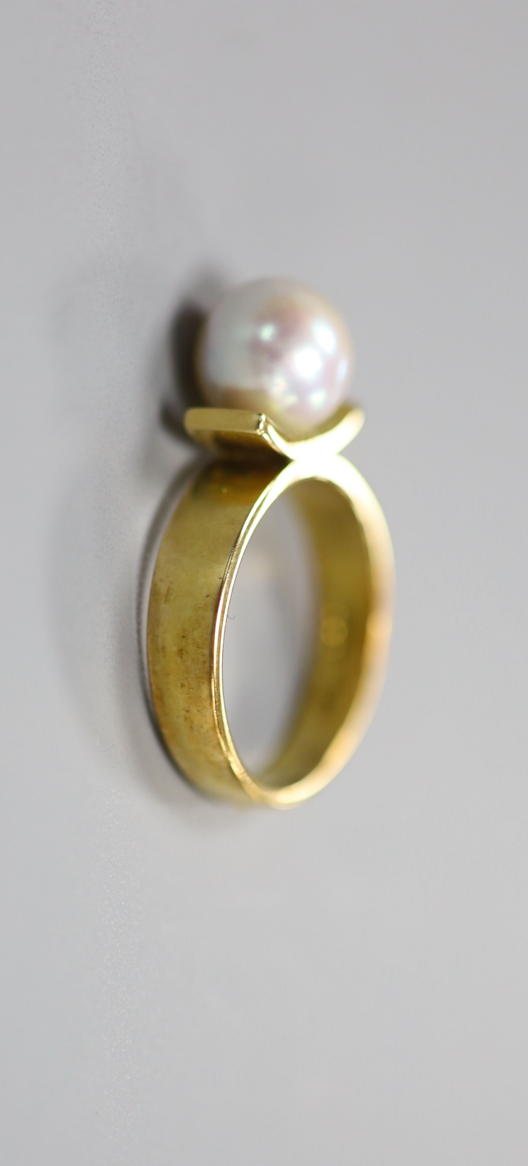 A modern 18ct and cultured pearl set dress ring, size M/N